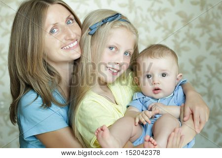 Two generations family portrait of happy mother with two adorable sibling children