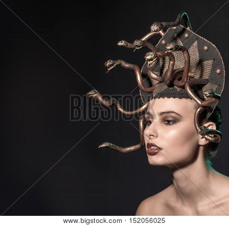 girl Medusa headdress of gold color on a black background.