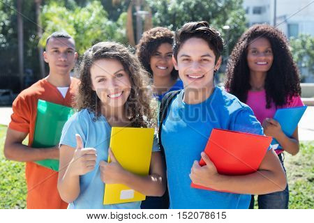 Group of five smart latin american caucasian and african students outdoor in the city in summer