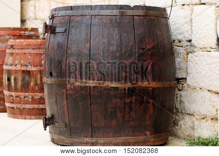 Wine barrels traditional oak wood casks tierces hogsheads coopered wooden containers closed with corks on stone wall background