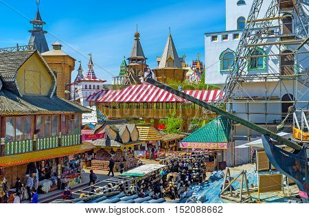 MOSCOW RUSSIA - MAY 10 2015: The view on Russian izba houses Izmailovsky Market stalls towers of Kremlin through the prow of the ship's replica on May 10 in Moscow.