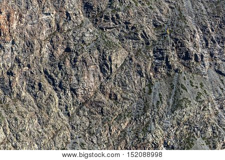 Scenic natural abstract background from texture of the mountain with stones scree and sparse vegetation
