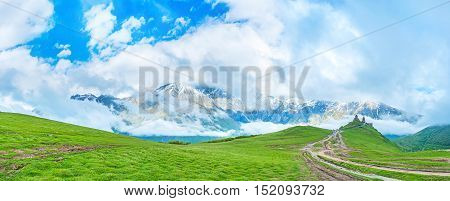 The low clouds move around the Kazbek Mount and fill the valley Gergeti Kazbegi Georgia.