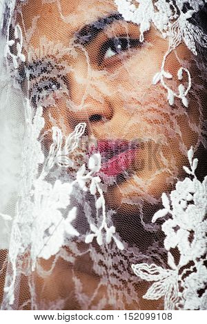 sensual portrait of beauty young afro asian woman through white lace, like new bride under veil close up