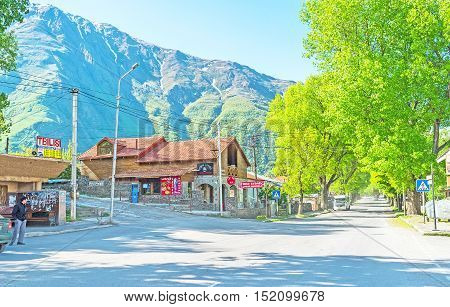 STEPANTSMINDA GEORGIA - JUNE 5 2016: The central town street with stores cafes and guest houses for tourists on June 5 in Stepantsminda.