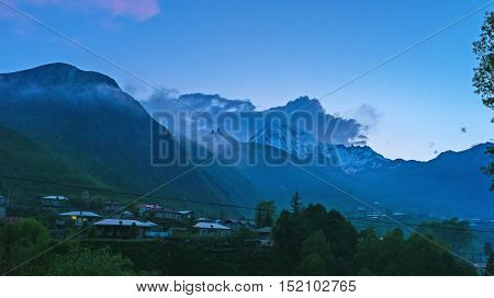 After the sunset the Kazbek Mount becomes mysterious its peak sometimes is seen through the dark clouds Stepantsminda Kazbegi Georgia.