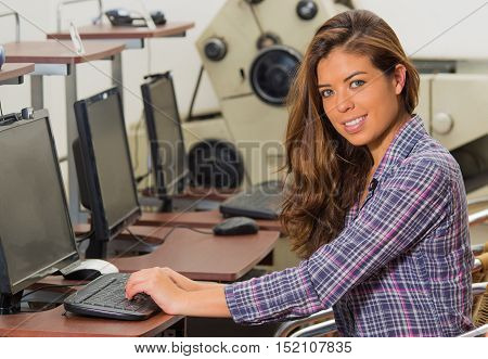 Beautiful woman with her hands on the keyboard and looking to the camera.