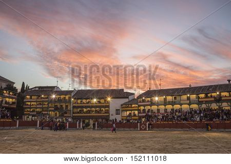 Chinchon Spain - October 15 2016: Plaza square Mayor of Chinchon adapted as a bullring Detail of balconies illuminated dressed with the Spanish flag beautiful sunset at Chinchon Spain