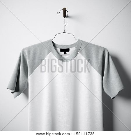 Closeup of blank white and gray cotton tshirt hanging in center of empty concrete wall. Clear label mockup with highly detailed textured materials. Square. Front side view. 3D rendering