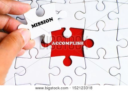 "ACCOMPLISH" word on missing puzzle with a hand hold a piece of "MISSION" word puzzle want to complete it - business and finance concept