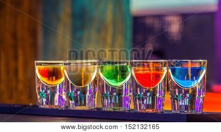 Colorful shot drinks in bar in night