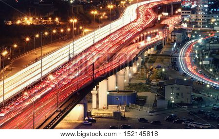 Traffic jam on automobile overpass at night view from above. light trails of cars on a highway.