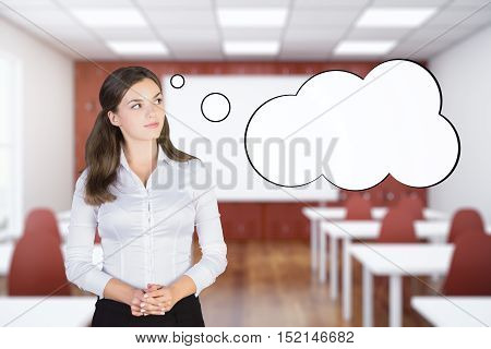 Pretty caucasian schoolgirl with empty thought cloud on blurry interior background. Mock up