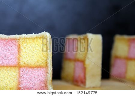 Freshly Cut Battenberg Cake Slices On Wooden Board With Dark Background. Pink And Yellow Sponge Cove