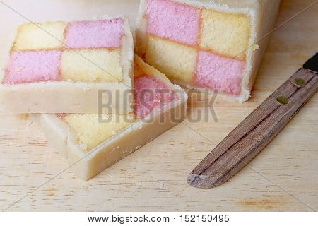 Freshly Cut Battenberg Cake With Knife. Pink And Yellow Sponge Covered In Marzipan