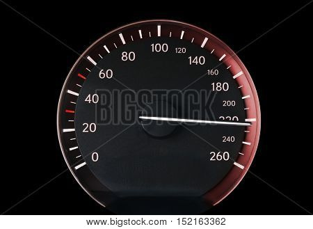 Speedometer of a car showing 220, glowing with red light