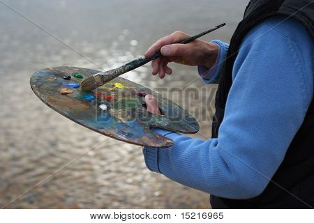 Reife Künstler mit Pinsel und Palette Malerei Küstenlandschaft.