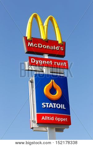 Eskilstuna, Sweden - June 14, 2014: Signs at Vasterleden for the fast food hamburger restaurant McDonalds and the Statoil service station isolated on blue sky. Both are newer closed.