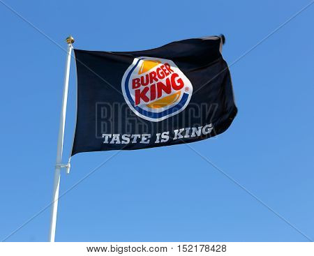 Eskilstuna, Sweden - June 14, 2014: Burger King flag on pole against blue sky at the restaurant located at the Vasterleden.