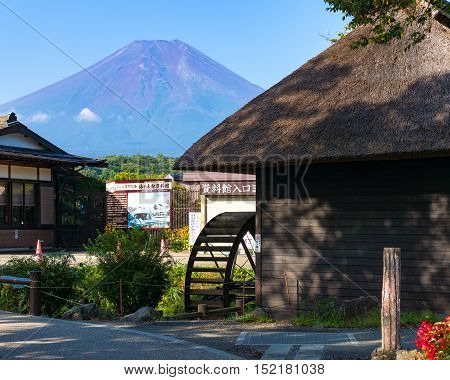 Oshino, Japan - September 2, 2016:Oshino Hakkai, Fuji Five Lakes. Japan countryside street with historic thatch roof farmhouses and Mt Fuji on the background