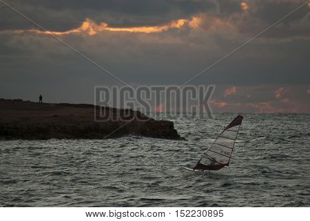 windsurfer at sunset near the shore of the sea