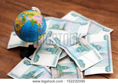 Russian money and the globe on wooden background