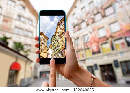 Photographing with smart phone old colorful buildings in the old town of Lucerne city in Switzerland