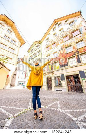 Young woman on the square with beautiful old buildings in the old town of Lucerne city in Switzerland