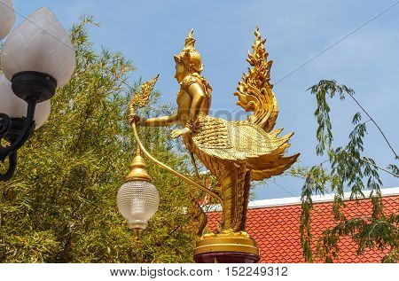Lamps of Kinnari in Thailand on temple roof background