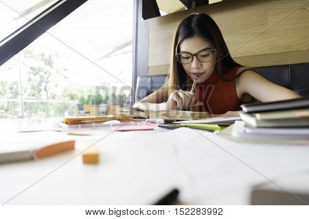 Collegian woman reading book in library. Education idea concept. Reading and researching for exam. The student life.