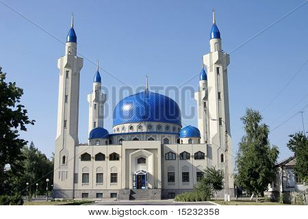 Moschea bianca con cupole blu contro un cielo impeccabili