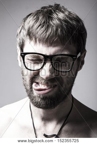bearded man in glasses plays the fool. crazy man, funny expression.