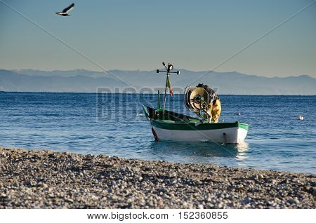 fishermen's arrival on the coast at dawn after a night of fishing with the sun kissing the sea