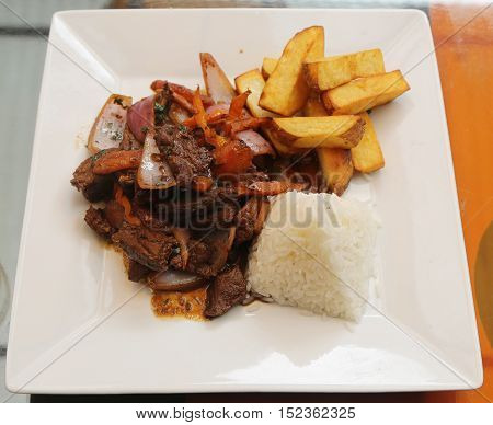Traditional Peruvian dish Lomo Saltado (Beef saltado). Lomo saltado is a stir fry that typically combines marinated strips of sirloin with onions, tomatoes, french fries and typically served with rice
