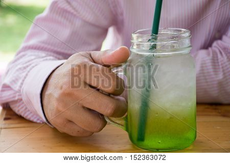 Man holding a mug of juice on wooden table
