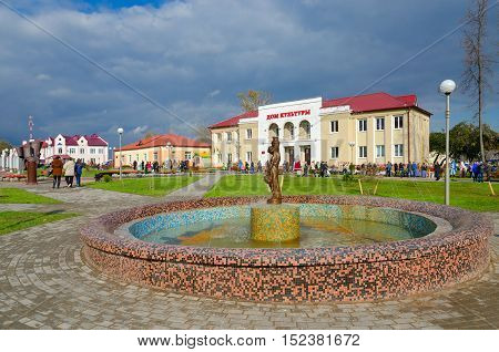 SENNO BELARUS - OCTOBER 8 2016: Unidentified people walk on town square near District House of Culture and fountain during regional festival-fair 