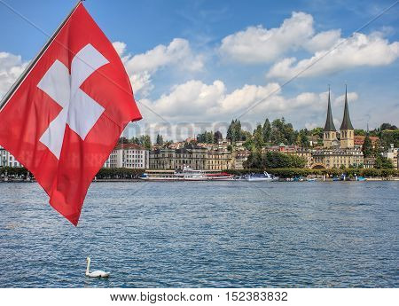 View in Lucerne, Switzerland: flag of Switzerland, Lake Lucerne with the city of Lucerne in the background.