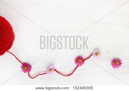 unwound a skein of thread of red color decorated with flowers / idea for fashion design