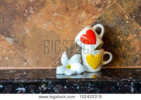 Coffee cups is overlapped with a Flower besideselective focus
