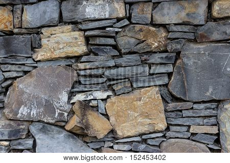 Fragment of the wall made of stones of different types and shapes