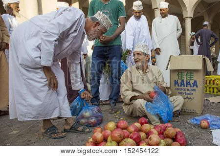 Nizwa Oman October 13th 2016: omani man selling pomegranates
