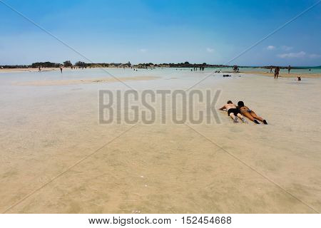 Elafonisi, Island Crete, Greece, - June 26, 2016: Swimming and relaxing people  on the beautiful beach of Elafonisi with pink sand