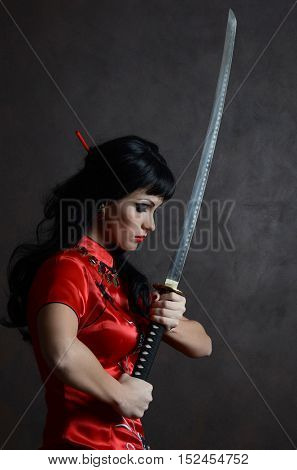 Beautiful geisha in kimono with samurai sword