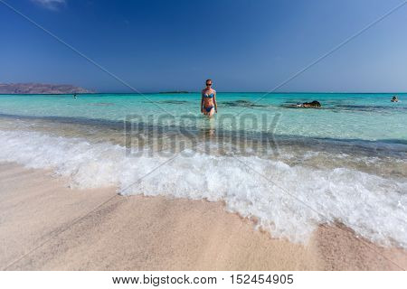 Elafonisi, Island Crete, Greece, - June 26, 2016: Swimming and relaxing people  on the beautiful beach of Elafonisi with pink sand