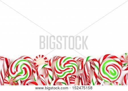 Christmas Candy Bottom Border With Lollipops, Peppermints And Candy Canes Over A White Background