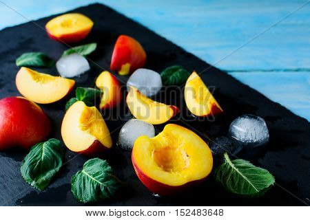 Slices of nectarines and peaches on blue wooden background. Fresh fruit background. Healthy eating concept with nectarines and peaches. Selective focus.