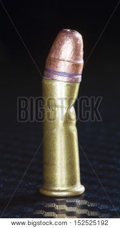 Rimfire cartridge that has been bent in the middle on graphite