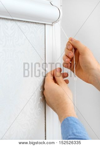 Man Testing Cassette Roller Blinds On Windows.