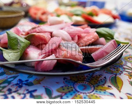 Close up of tasty sliced fresh herring fillets served with basil