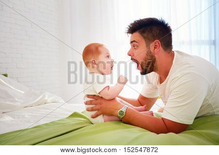 Funny Father And Baby Look At Each Other With Amazement
